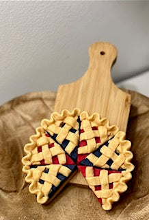 Lattice Pie Slice Wax Melts sitting in a bowl against a cheese board