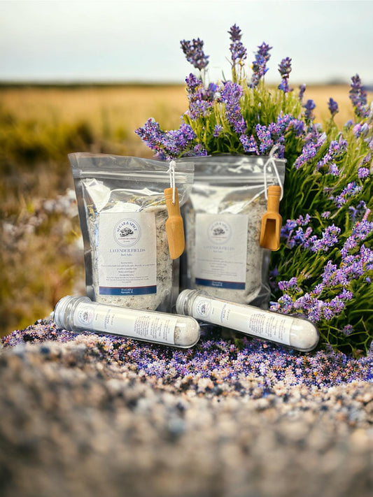 Lavender and butterfly pea bath salts packaged with a background of lavender and a field