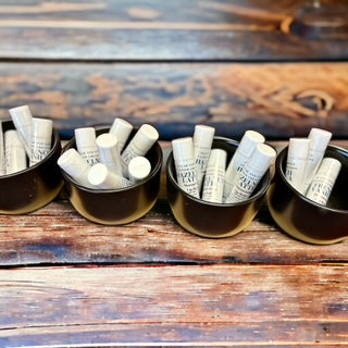 Lip Balms in black containers sitting on a wooden table